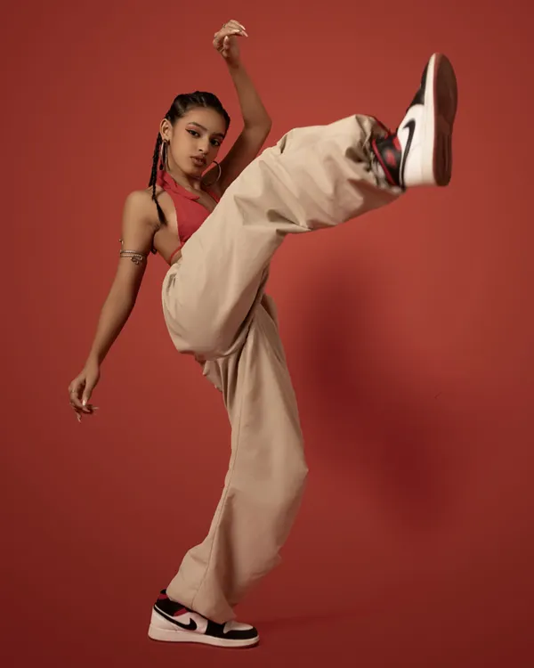 A dynamic shot from a professional photoshoot, capturing the energy and power of a high kick. This reflects the athletic side of my dance style.