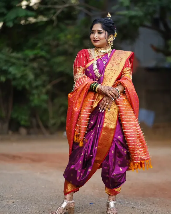 A majestic Maharashtrian bride in a traditional Peshwai Nauvari saree. I specialize in the intricate draping of this nine-yard wonder and pair it with bold makeup, a classic nath, and a crescent bindi to complete the royal look.