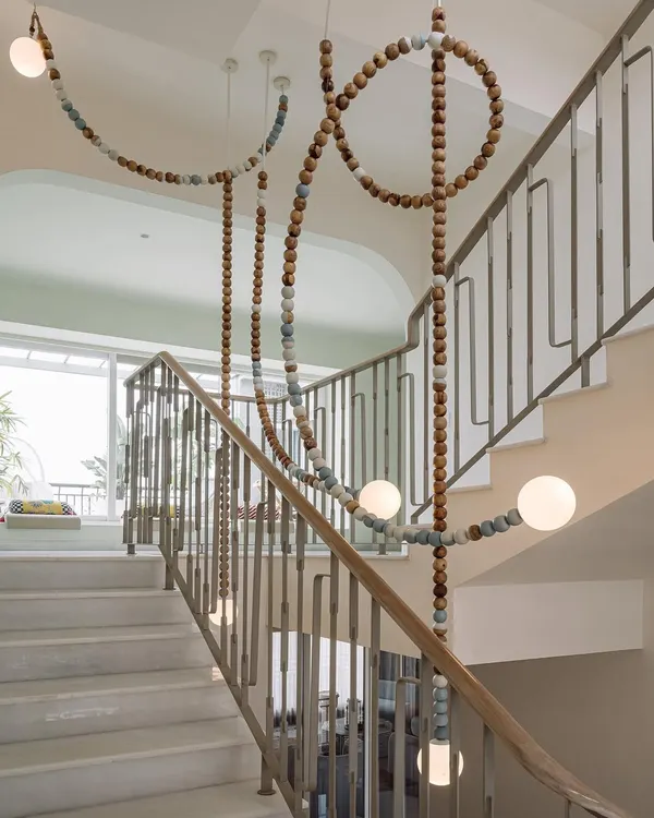 The LUNA light installation, a collaboration with Mother Gone Mad, cascades down the stairwell of Eden House. The wooden and ceramic beads create a natural, earthy feel, while the glowing orbs add a touch of magic.