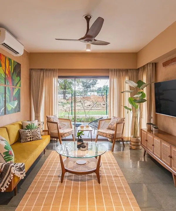 The living room of the Earth Villa, where lime-plastered walls create a warm, textured envelope. I selected mid-century modern furniture in natural wood and cane to complement the earthy aesthetic, while the large window frames a view of the surrounding landscape.