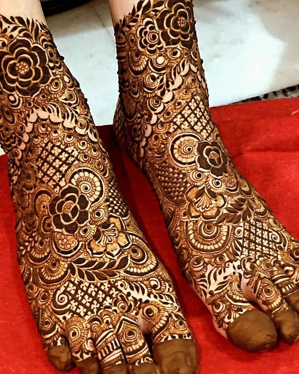 This is a perfect example of full-coverage bridal foot mehendi. The design is dense with floral and net patterns, covering the entire foot for a rich and traditional look.