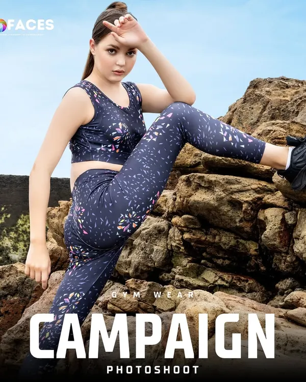 A model in printed gym wear strikes a powerful pose on a rocky shore. This outdoor campaign shot perfectly blends the ruggedness of nature with the performance of the activewear, creating a strong brand image.