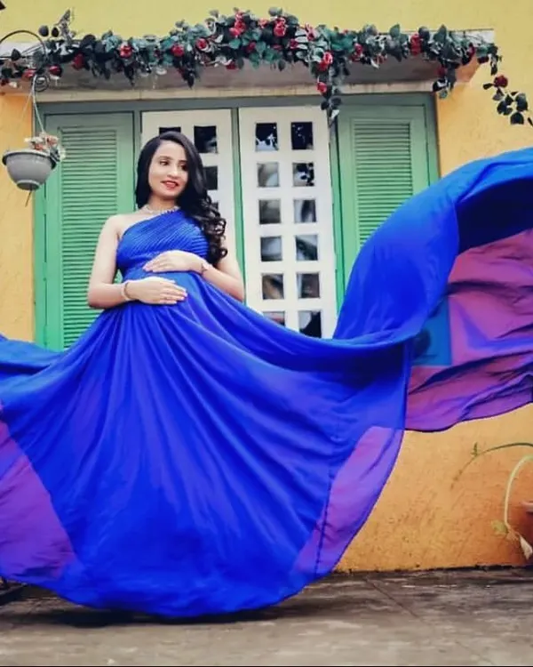 The incredible royal blue fabric of this flying gown creates a wave of color. This shot demonstrates the stunning visual impact these gowns have, perfect for a one-of-a-kind maternity portrait.