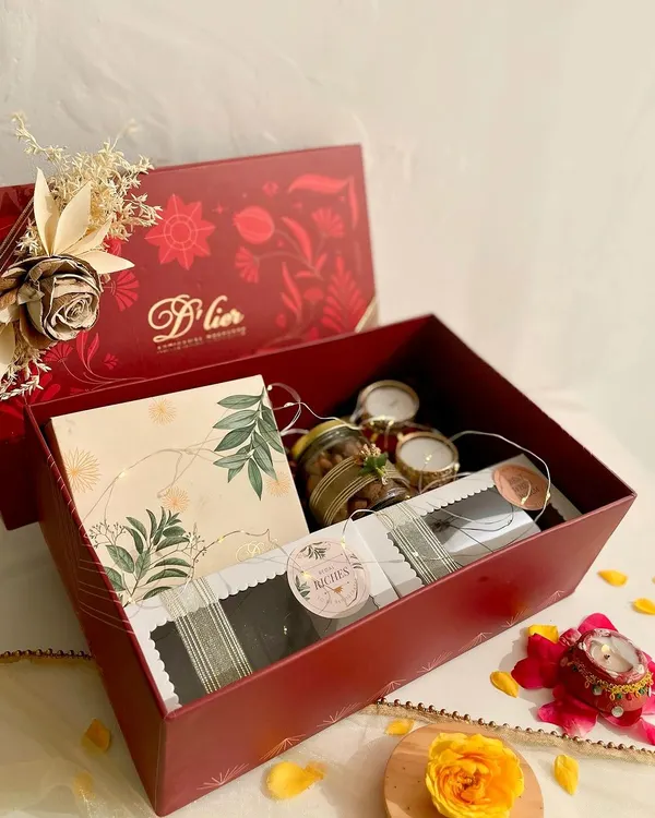 This is our premium festive hamper, a luxurious red box filled with an assortment of our finest handmade desserts. It includes boxes of truffles, Belgian chocolate brownies, our signature Regal Riches, jars of chocolate-coated almonds, and festive diyas, all beautifully arranged to create the perfect Diwali gift.