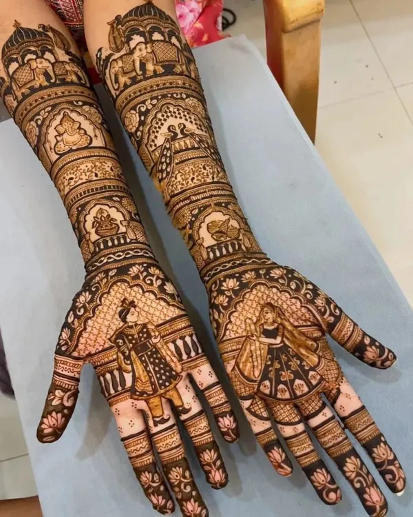 A stunning full bridal design with detailed bride and groom figures on the palms. The arms are covered in traditional wedding scenes, including palanquins and elephants, for a truly narrative-driven mehndi.