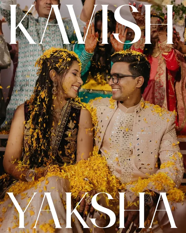 The quintessential Haldi moment. Covered in flower petals, the couple shares a look of pure happiness. This image captures the vibrant, joyful, and slightly chaotic spirit of the ceremony that we love.