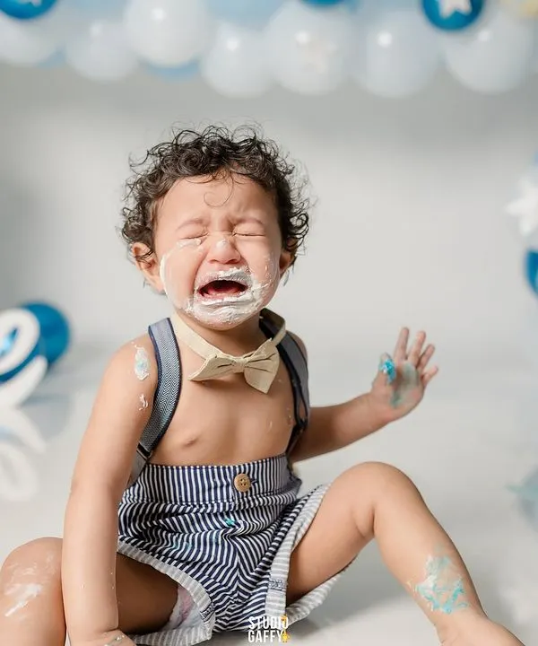 Sometimes a cake smash is just too much excitement! This photo captures the hilarious and very real tears that can happen during a first birthday celebration, a memory to laugh about for years.