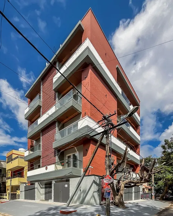 An angular view of the 'Vihaan' apartment building, showing how the design engages with its corner plot in HSR Layout.