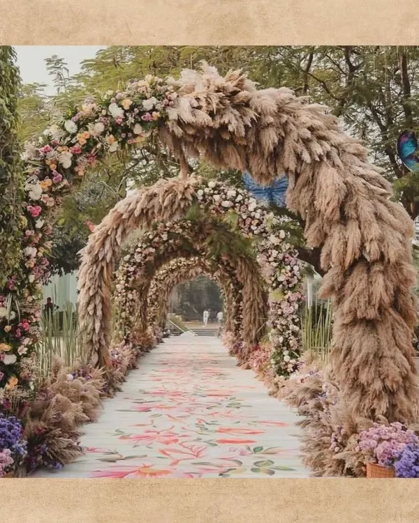 I love creating pathways that tell a story. This bohemian-inspired wedding entrance features grand arches of pampas grass and delicate florals over a custom-printed carpet, guiding guests through a whimsical, rustic tunnel.