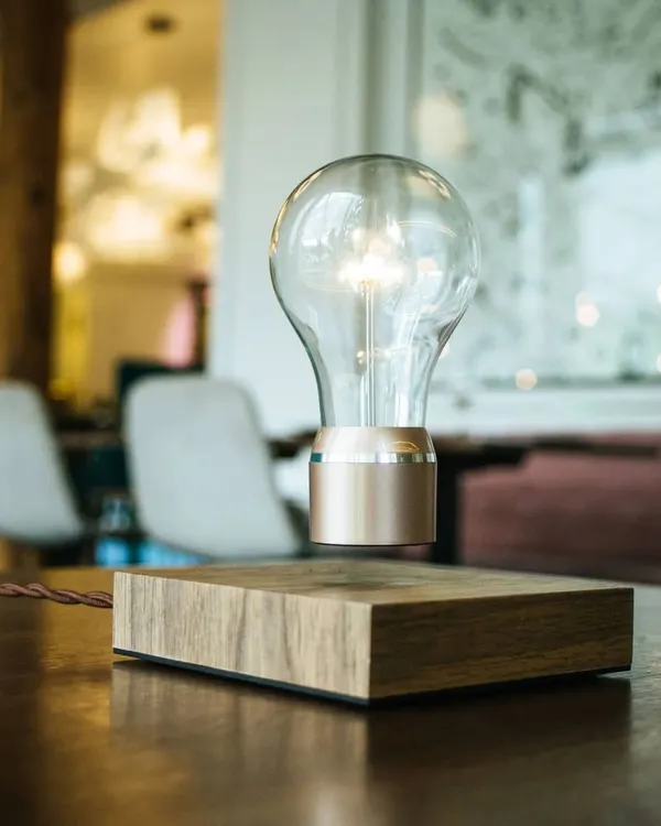 Our FLYTE levitating light bulb, shown here in the Buckminster model, floats effortlessly over a sustainably sourced wooden base. It serves as a captivating centerpiece on a coffee table or desk, blending warm ambient light with futuristic technology.