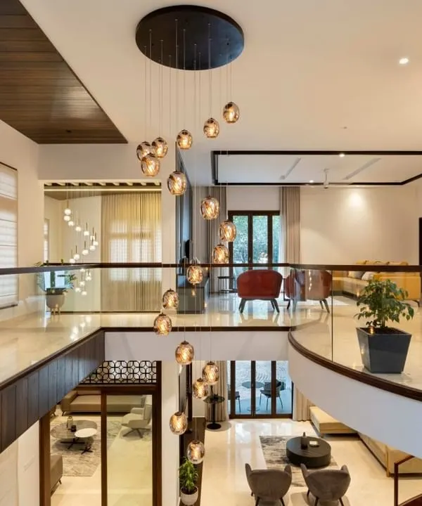 Looking down from the second-floor gallery, you can appreciate the scale of this open-concept home. The spiral chandelier cascades through the double-height void, connecting the upper and lower levels into one cohesive, light-filled space.