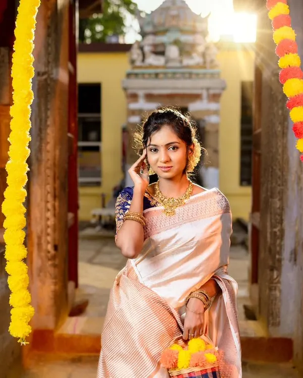 A classic Onam look featuring our simple yet elegant gold-finish necklace set. This photo, taken in a temple corridor, shows how our jewellery is perfect for traditional festivals.