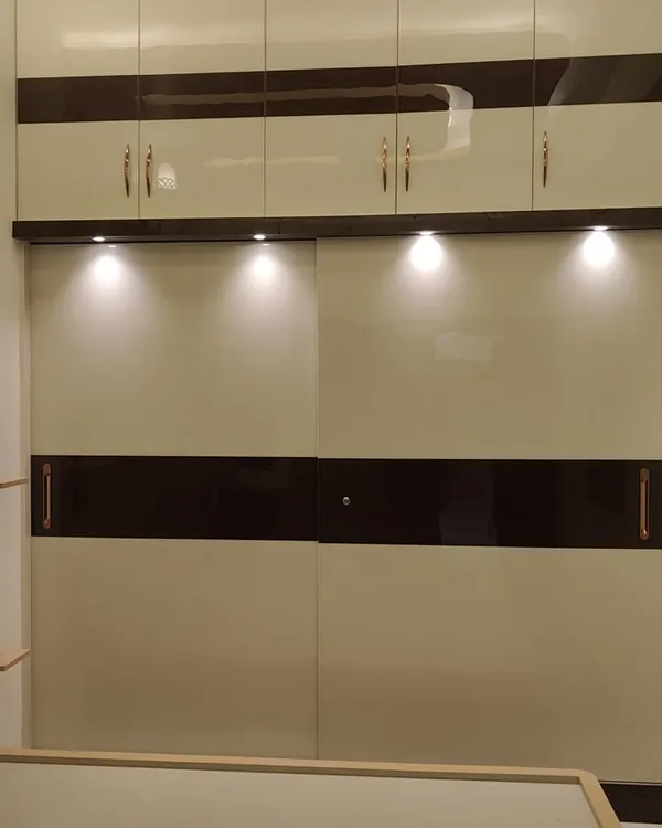 This two-tone sliding wardrobe features a high-gloss finish that is both stylish and practical. The combination of white and dark bands creates a contemporary look, and the polished surface is easy to clean and maintain.