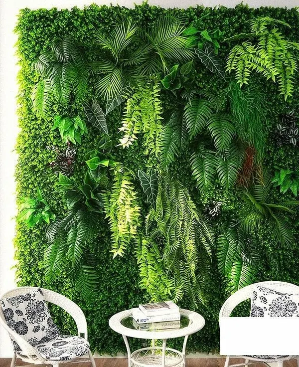 This artificial green wall creates a stunning, maintenance-free feature in a living room. The design uses a mix of ferns and hanging plants for a realistic, multi-layered look.