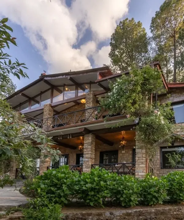 The exterior of our Buransh Terraces project, a mountain home built with local stone and designed to feel like a natural extension of the Himalayan landscape. The multi-level terraces and large windows maximize the stunning views.