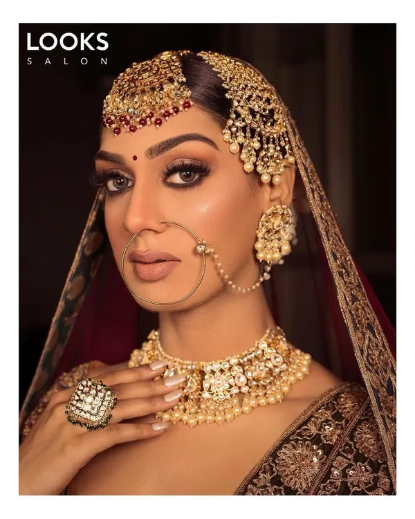 Our signature HD bridal makeup, designed to be flawless in person and in high-definition photos. This look features expertly blended eyeshadow, sharp contouring, and a bold lip, ensuring our bride is the radiant center of attention on her wedding day.