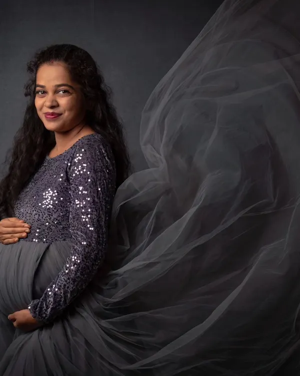 Capturing the magic of motherhood with a dramatic, flowing gown against a classic dark backdrop. This is one of my favorite ways to create timeless maternity art that feels both powerful and elegant.