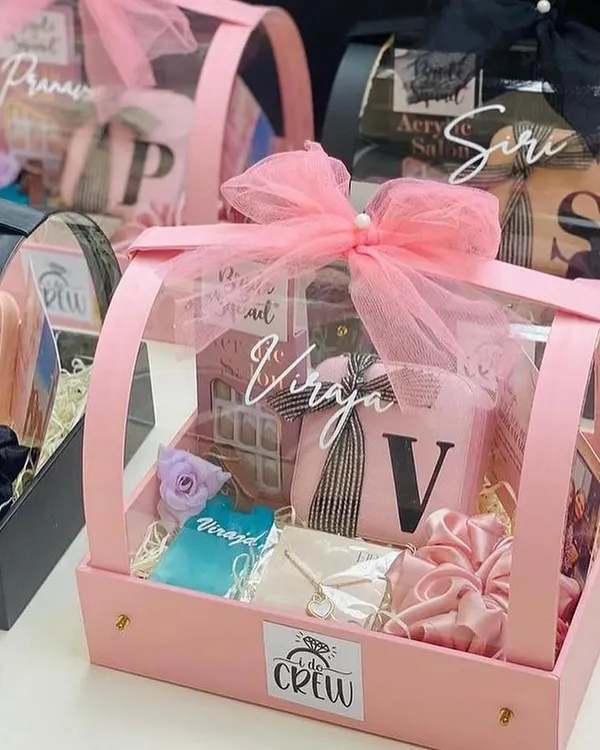 A gorgeous bridesmaid proposal hamper, shown here in a chic pink and black theme. We packed this acrylic basket with personalised goodies like a custom candle, scrunchies, and a photo frame to make her feel extra special.