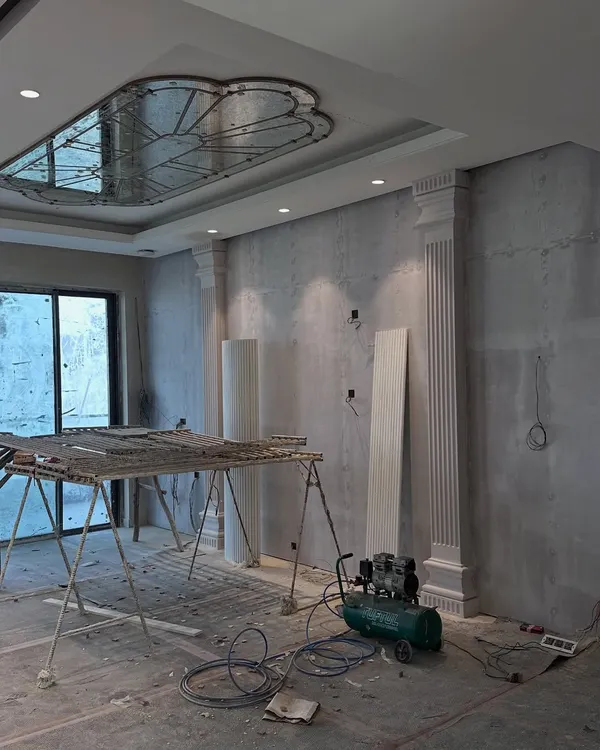 Before: The living room of our Gulshan Dynasty project during the initial civil work phase, with structural elements like pillars and ceiling details being put in place.