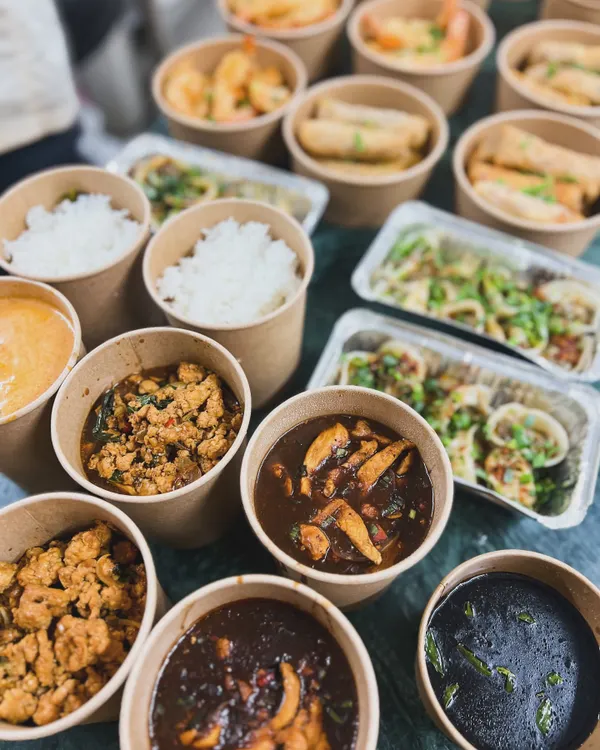 A large Asian food delivery order, ready to go. This spread includes our popular Thai curries, rice, noodles, and appetizers, all packed and ready to be enjoyed at home.