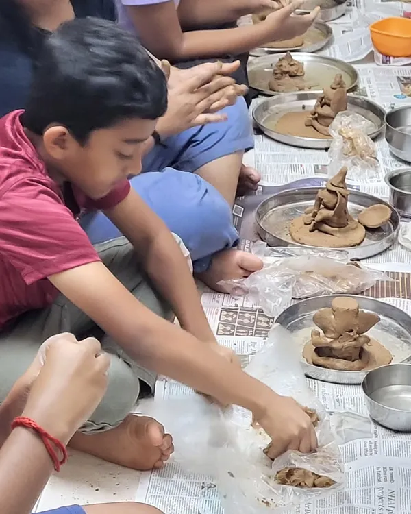 A young artist deeply focused on sculpting his Ganesha idol from clay. These tactile activities are wonderful for developing fine motor skills and concentration.