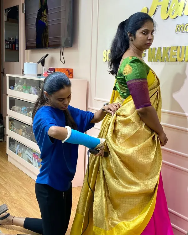 Dedication in action. This student, even with a cast on her arm, is determined to master the art of saree draping. It's this passion that makes a great artist.