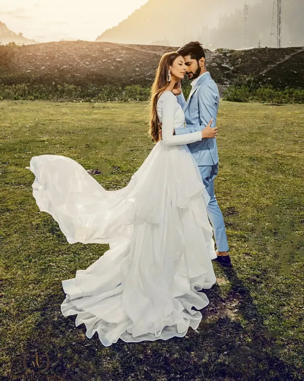 A truly epic shot from our pre-wedding shoot in Sonmarg, Kashmir. The bride's flowing white gown against the vast green meadow and distant mountains creates a breathtaking, fairytale-like image. This is what destination photography is all about.