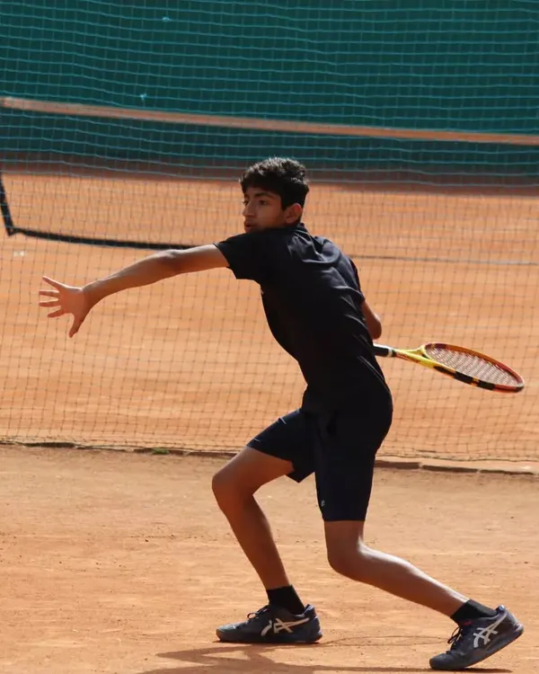 A junior player executing a powerful forehand during a tense semi-final match. The focus and technique on display were outstanding.