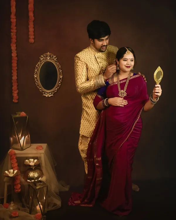 A beautiful moment from a traditional maternity session. The husband helps his wife with her earring, a small, intimate gesture that speaks of their love and partnership.