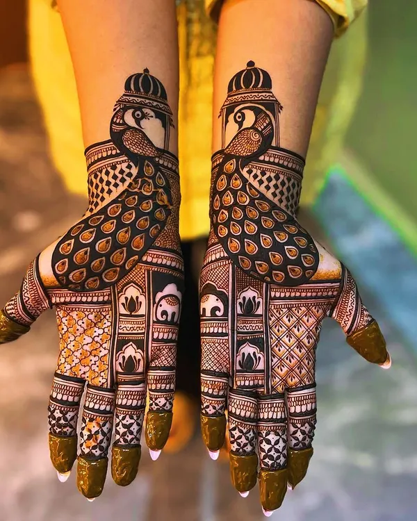 A stunning example of symmetrical peacock designs. Each hand features a majestic peacock with an elaborate tail, complemented by elephant and lotus motifs within the intricate grid work on the palm.