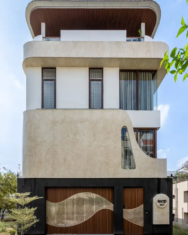 We designed the Avani Residence with a fluid, sculptural facade that creates a dynamic play of volumes and voids. The seamless lines and interplay of textures give this compact home a distinctive and modern architectural identity in Bangalore.