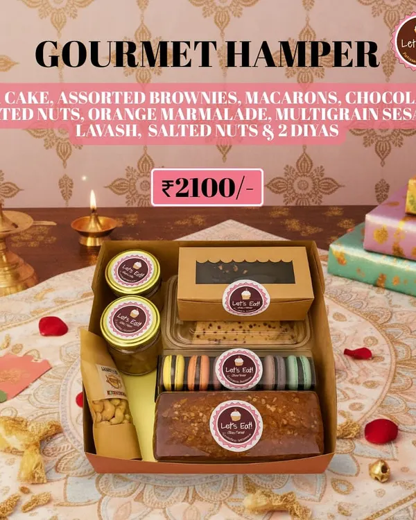 My grand Diwali Gourmet Hamper, featuring a full spread of handmade sweets and savouries. It includes a tea cake, assorted brownies, macarons, chocolate nuts, orange marmalade, multigrain lavash, salted nuts, and two decorative diyas.