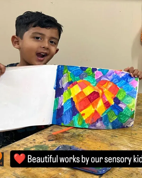 This vibrant heart mosaic is a beautiful exploration of color blocking. The student's joyful expression shows how proud he is of his work, and we are proud of him too!