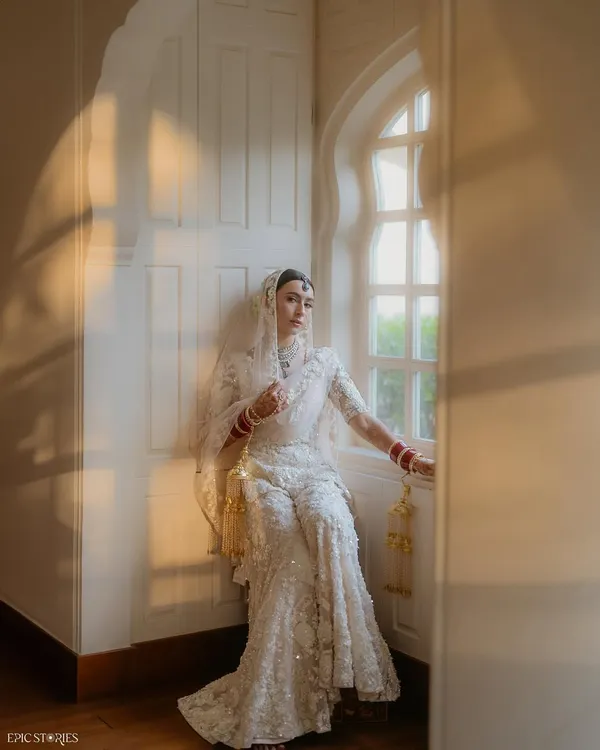 A moment of quiet solitude for the bride, Sejal, by the window. The beautiful play of natural light and her elegant white chikankari lehenga created a portrait that is both serene and absolutely timeless.