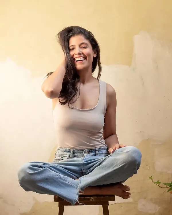 A genuine, laughing portrait in a casual tank top and jeans. This shot captures my natural, happy energy, perfect for relatable lifestyle content.