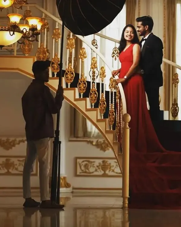 A behind the scenes look at a photoshoot in a grand location. Our team and the photographers work together to get the perfect shot of our red trail gown.