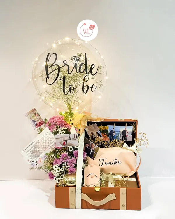 The ultimate bridal bliss hamper. This vintage-style trunk is filled with personalized gifts, a floral arrangement, cherished photos, and a "Bride to be" balloon to make her feel truly celebrated.