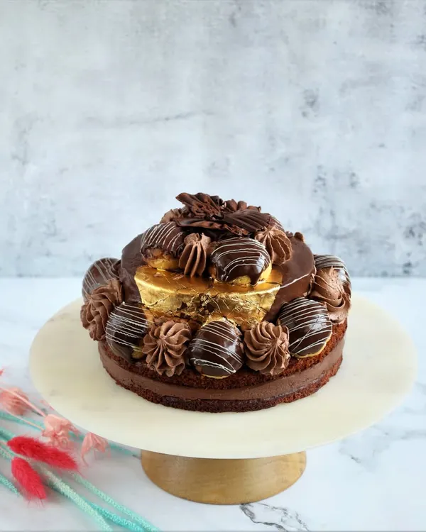 This is our Desire 3 Cake, a true chocolate adventure. We pair dark couverture chocolate with our house-made dacquoise, rich mousse, and creamy panna cotta, then garnish it with 99% pure gold varak for a touch of luxury.