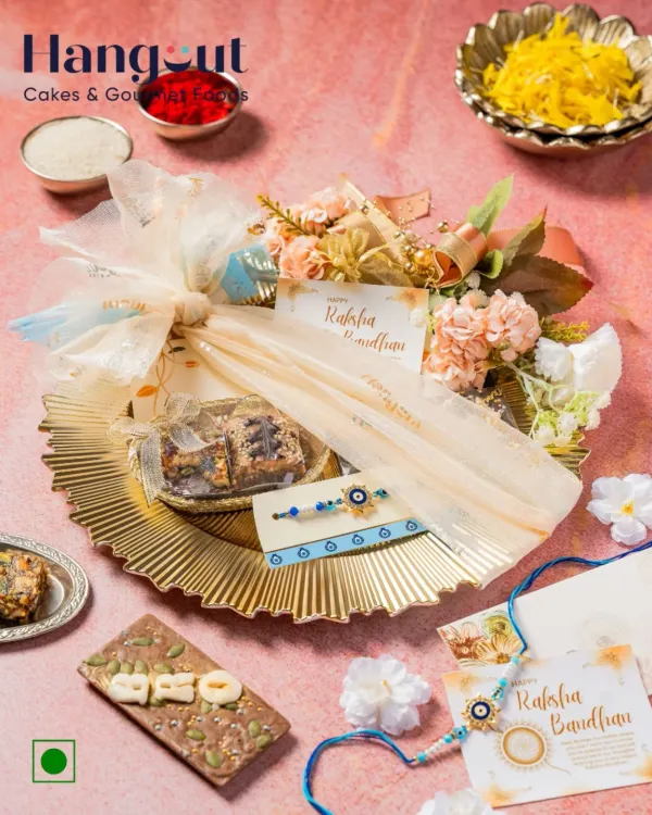 My Pooja Thali Rakhi Gift Hamper has everything your sibling needs. It includes brownies, a nut bar, mithai, and an Evil Eye Rakhi, all beautifully arranged on a golden platter.