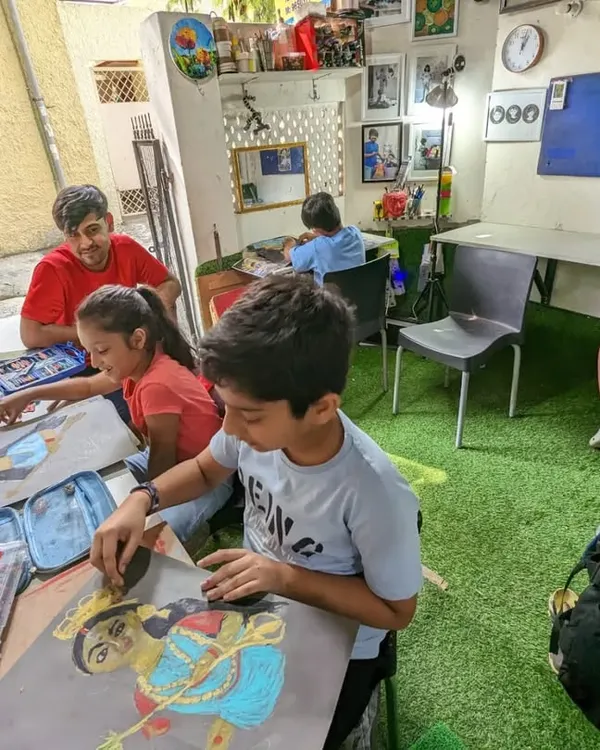 A wide view of my drawing class in session. Students are busy working on their individual pieces, using reference images to create stunning portraits with oil pastels.
