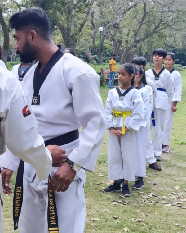 This is what my coaching is all about: building discipline and focus from a young age. Here, I am guiding my students during an outdoor Taekwondo session, making sure they stand with respect and readiness.