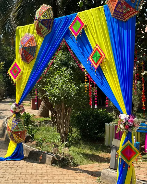 The entrance to Niharika and Ashish's Mehandi celebration. We used vibrant blue and yellow drapes, accented with traditional Rajasthani umbrellas and hangings, to create a festive and colorful welcome.