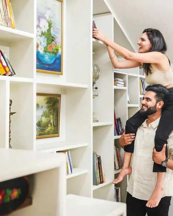 A pre-wedding shoot should be fun. This playful moment, with her on his shoulders reaching for a book, is full of genuine laughter and joy. It’s a perfect example of how I capture your real personalities during an indoor couple shoot.