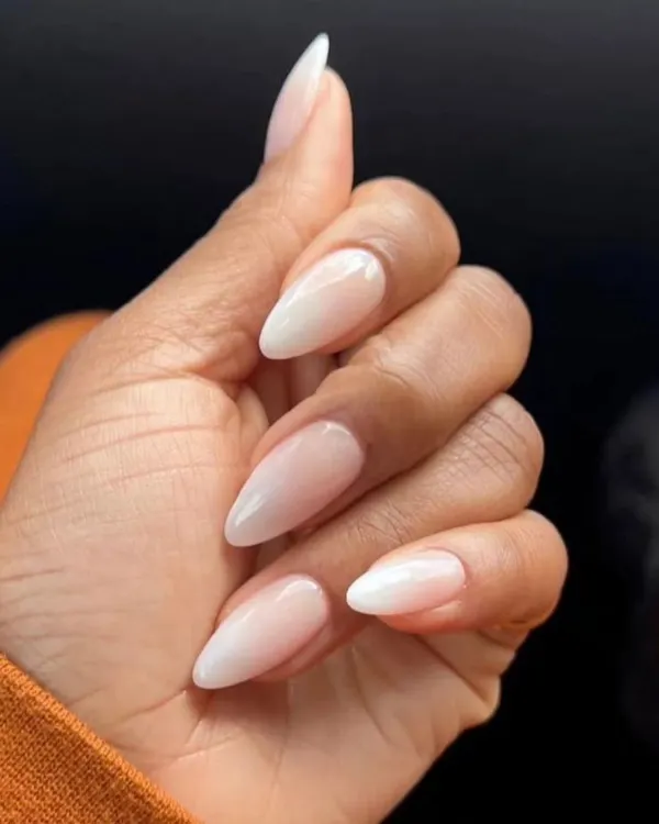 A perfect example of a classic baby boomer manicure, with a seamless ombre blend from a soft pink base to a milky white tip on almond-shaped nails.