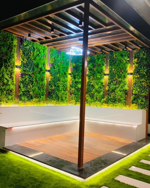 A completed pergola in Sonipat with built-in L-shaped seating, vertical garden walls, and integrated lighting.