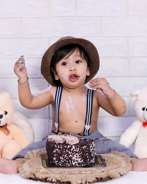 The aftermath of a successful cake smash. This little one is enjoying every last bit of his first birthday cake.