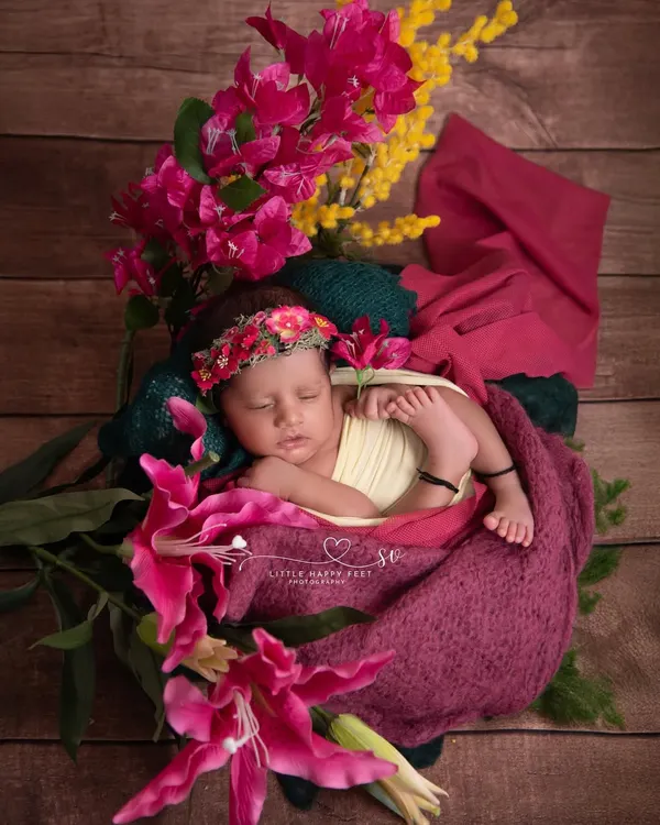 Wrapped in love and surrounded by vibrant pink and yellow flowers. This colorful, floral-rich setup is perfect for welcoming a spring or summer baby.