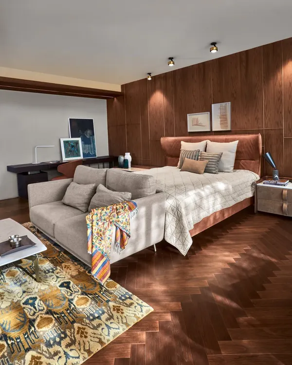 A serene bedroom at the Baid Residence, featuring a luxurious rug from Jaipur Rugs and elegant Tato lamps from Lightbox Delhi. The space is a harmonious blend of comfort, style, and curated art.