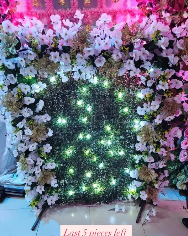 This ready-to-book backdrop features a green grass wall with a border of white flowers and golden accents, illuminated with built-in fairy lights. It's a beautiful and easy way to create a festive corner. Only 5 pieces left!