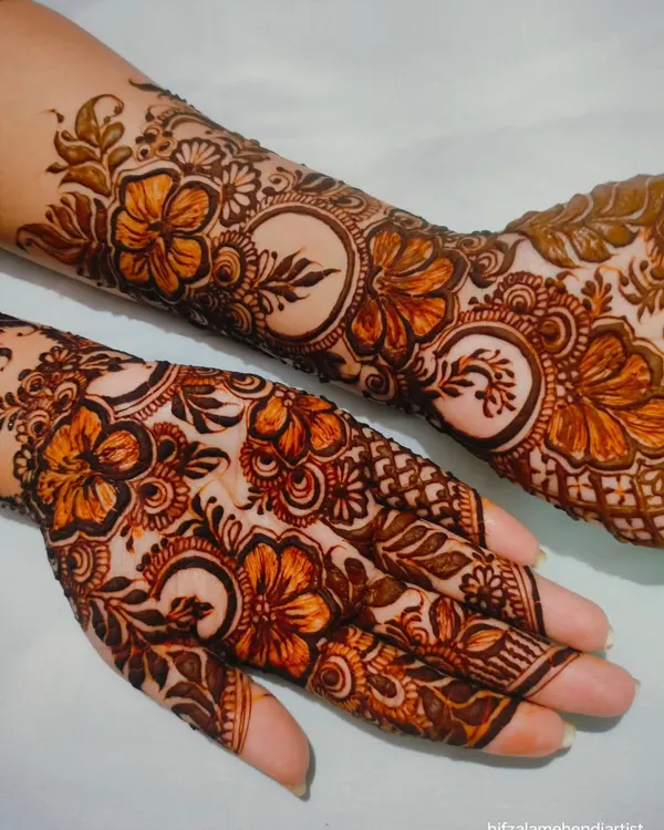 A beautiful henna design adorned with hibiscus flowers. This is one of my favorite floral motifs to create, with its delicate petals and leaves covering the hand and arm.